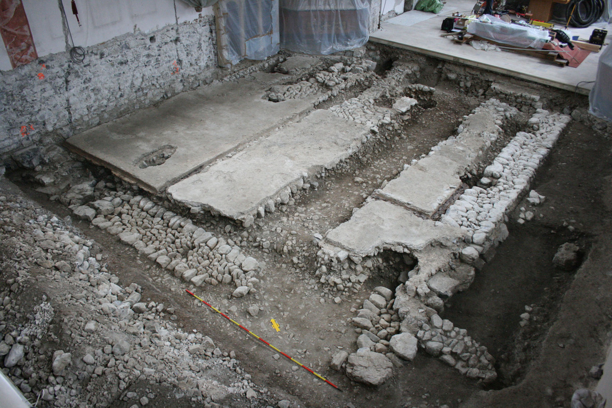 Überblick über den gesamten Grabungsbereich. Gut ist die spätgotische Norderweiterung des romanischen Bestandes an der Kirchenwestmauer erkennbar. Rechts unten im Bild sind die Reste der spätgotischen Vorhalle sichtbar.